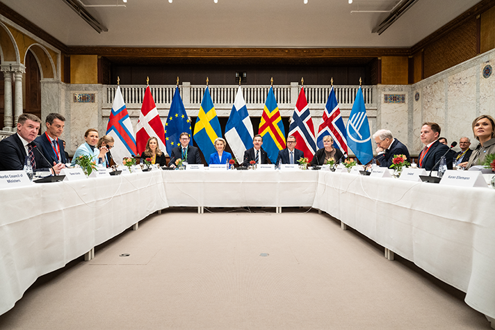 The Nordic prime ministers and heads of government and Ursula von der Leyen sitting at a horseshoe-shaped table in a meeting room. Behind them is a row of flags: Faroe Islands, Denmark, EU, Finland, Sweden, Åland, Norway, Iceland, Nordic Council.