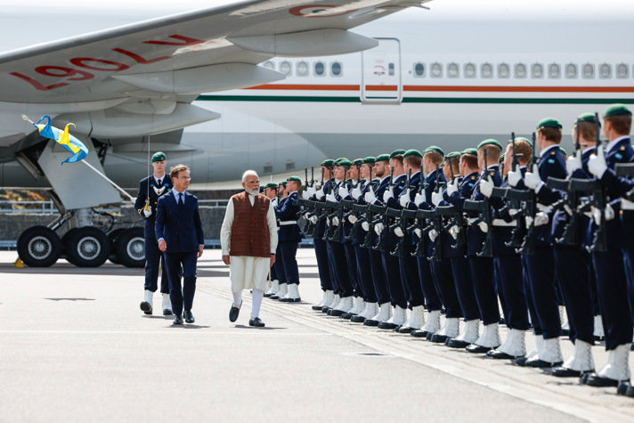 Ulf Kristersson and Narendra Modi walk past a guard of honour, with soldiers from the Swedish Armed Forces lined up in formation.