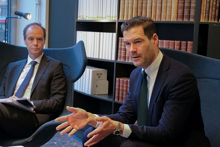 Minister for Migration Johan Forssells in a chair discissing with colleagues.
