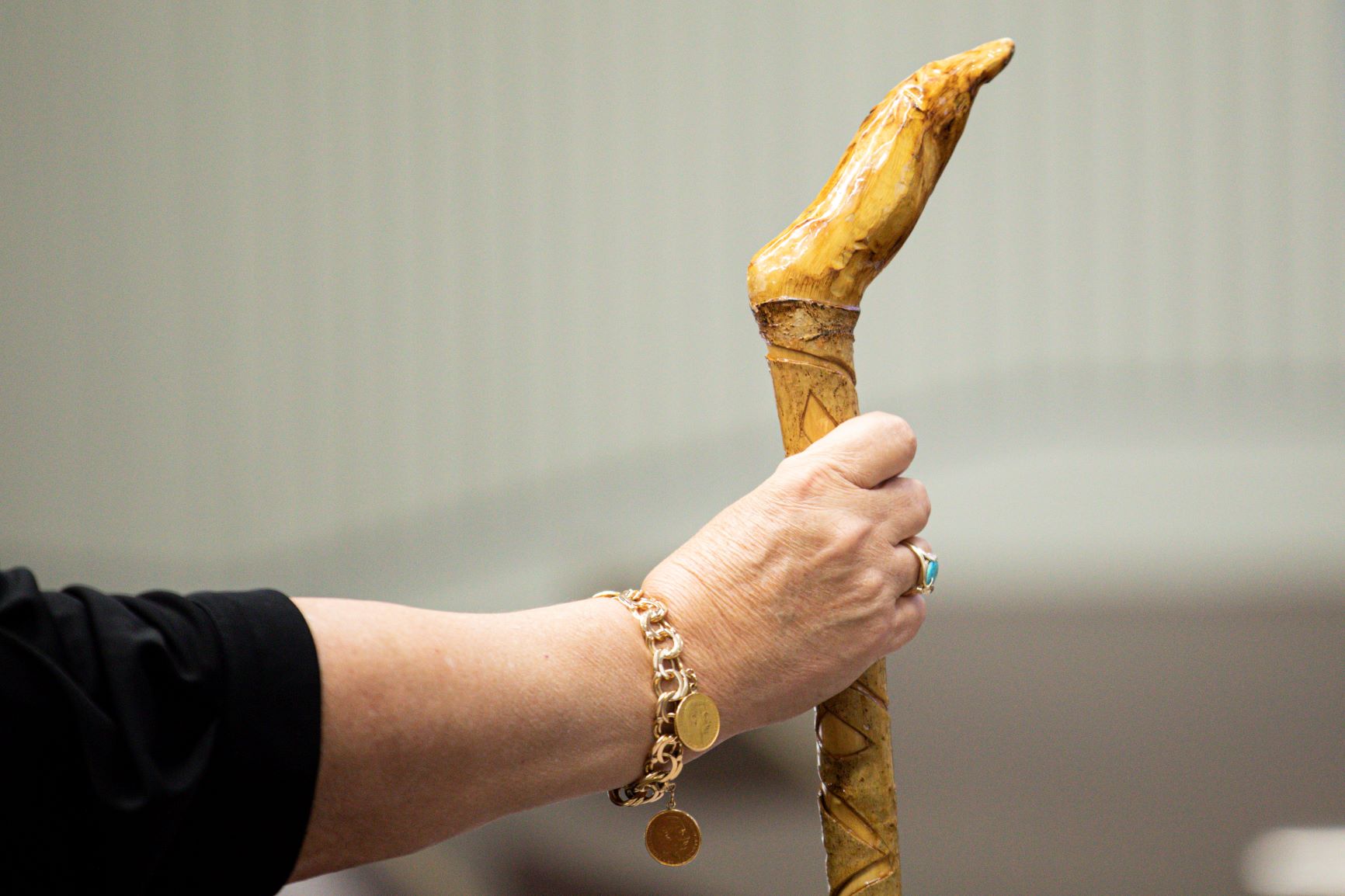 A close up on a person holding a wooden stick with a firm grip