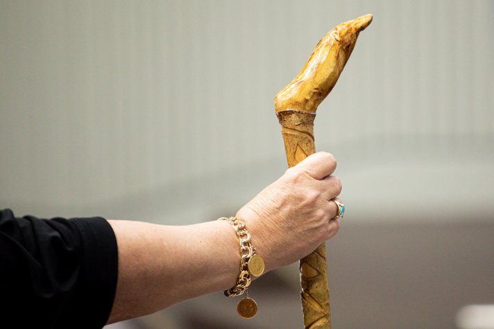 A close up on a person holding a wooden stick with a firm grip