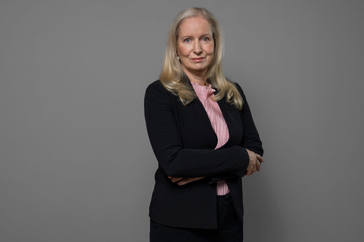 Half-length portrait of Anna Dahlberg against a grey background.