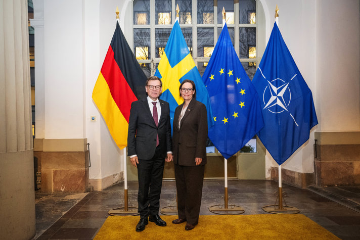 Maria Malmer Stenergard and Johann Wadephul standing in front of flags.